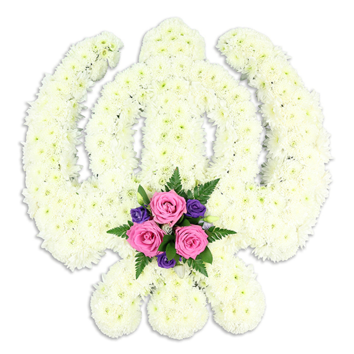 A beautiful and profoundly respectful Sikh Khanda floral tribute is shown in full against a seamless white background, allowing every detail of the sacred symbol to stand out with clarity. The entire Khanda - the central double-edged sword, the surrounding chakkar, and the two protective kirpans sweeping outwards and down - is formed from densely packed white chrysanthemums or similar small-headed blooms. Each flowerhead is placed closely beside the next, creating smooth, rounded edges and crisp inner lines so that the complex shape reads clearly even from a distance. The white petals, some leaning toward soft cream, create a gentle variation in tone that adds depth and softness, like layers of fine fabric. At the base, where the tips of the kirpans cross, the eye is drawn to a carefully composed accent posy. Three prominent pink roses, fresh and velvety, sit at the heart of this cluster, their spiralling petals opening in quiet beauty. Around them, deep purple flowers and sprigs of lush green fern provide contrast and movement, suggesting both solemnity and hope. The tribute appears to float above a faint shadow, hinting at its three-dimensional form and the sturdy frame supporting it from behind. The overall effect is serene yet powerful, capturing the essence of Sikh faith and the respect accorded to a cherished life. In Hatch End, this is the kind of bespoke Khanda arrangement families might request from Flower Delivery Hatch End when arranging a Sikh funeral or memorial service, whether for a ceremony near Uxbridge Road or a farewell gathering at a local gurdwara. It serves not only as a floral display but as a symbol of spiritual strength, remembrance, and enduring love.