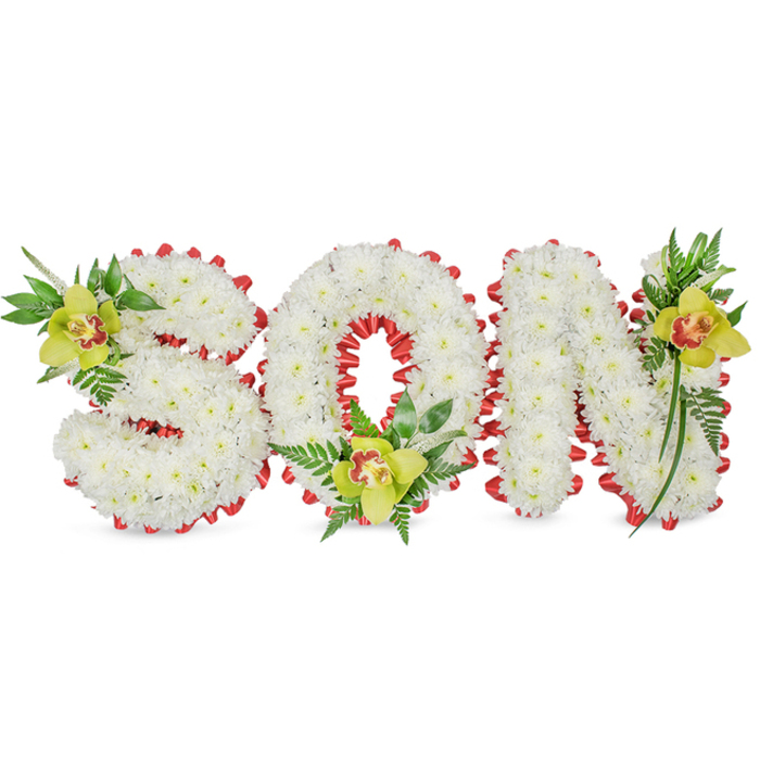 This dignified floral composition spells the word 'SON' in bold three-dimensional letters, each letter meticulously covered in a dense carpet of small white chrysanthemums whose layered petals form a plush, cloud-like surface. The arrangement is set against a plain white background, allowing the purity of the chrysanthemums to read as calm and reverent. Encircling the edges of every letter is a continuous red ribbon, folded into small scallops that border each shape and trace the hollow centre of the 'O'; the ribbon's rich crimson introduces a poignant, contrasting accent that suggests love, courage, and remembrance. Accentuating the design are three yellow-green Cymbidium orchids with a warm reddish-brown marking in their throats: one tucks into the upper curve of the 'S', another nests at the base of the 'O', and a third sits at the upper right of the 'N'. These orchids, with their waxy petal texture and subtle perfume, are cushioned by varied green foliage - long elegant leaves, glossy blades, and airy fern fronds - which extend upward and outward to add verticality and a gentle, natural silhouette. The overall effect is both carefully crafted and quietly expressive, combining sculptural form with botanical softness. This piece is ideally suited to funeral or memorial use, intended to convey deep affection and a personal tribute to a son. As a local note, this style is often requested by families around Hatch End, Pinner and nearby streets when they seek a tasteful, personalised floral message for a service.