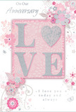 This anniversary card looks like a delicate piece of paper artistry, lovingly designed with the same care a Hatch End florist gives to a favourite couple's bouquet. The central element is the word LOVE, set in soft, raised letters that glimmer with a veil of blush and silver glitter. The gentle embossing gives the impression of depth and invites a fingertip to follow the shape of each letter, the sparkle restrained yet radiant, reminiscent of lantern light along West End Lane on a quiet evening. Replacing the typical plain lettering, subtle textural variations and pearly highlights add to the sense of something special kept for milestones. Around this central word, clusters of stylised flowers in blush pinks and muted mauves stretch outward, their petals drawn with fluid, almost watercolor lines that fade softly at the edges. Slender leaves and trailing vines wind between the blossoms, creating loose, flowing movement, like stems arranged with purposeful ease in a glass vase. Tiny butterflies and swirl motifs are tucked among the flowers, lending a sense of gentle motion, as though the design is breathing. The background holds to a soft, powdery pink, with touches of silvery grey and white that lend a refined, modern feel. Elegant script lettering carries phrases such as On Our Anniversary and I love you today and always, set just bold enough to be clearly read without disturbing the peaceful balance of the artwork. Overall, the card conveys a whisper-soft yet deeply felt celebration of shared years together in Hatch End, as tender and thoughtfully composed as a favourite anniversary bouquet.